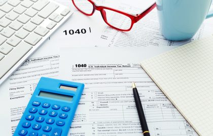 Income tax return form with computer keyboard calculator and notebook